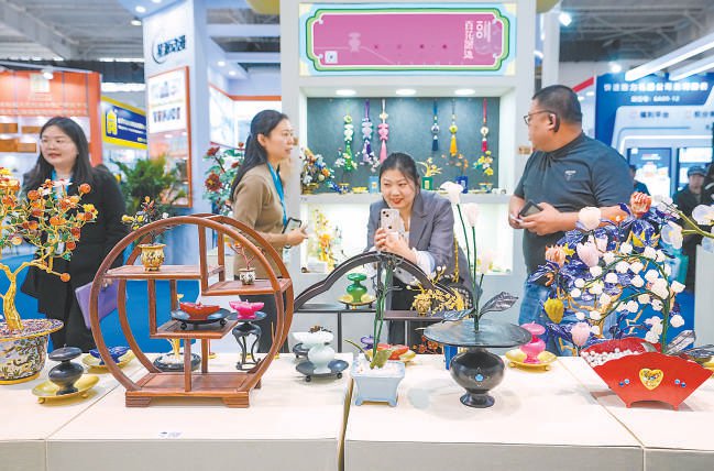 北京礼品家居展昨天在中国国际展览中心（朝阳馆）开幕，现场展示的工艺美术品吸引参观者驻足。 本报记者 武亦彬摄